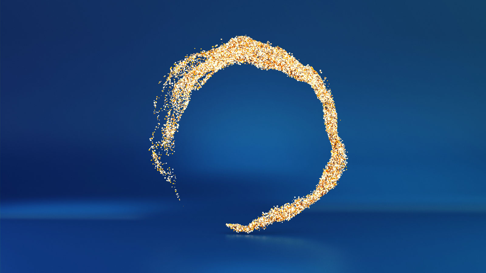 An organic circle ribbon of gold glitter on a dark blue background.